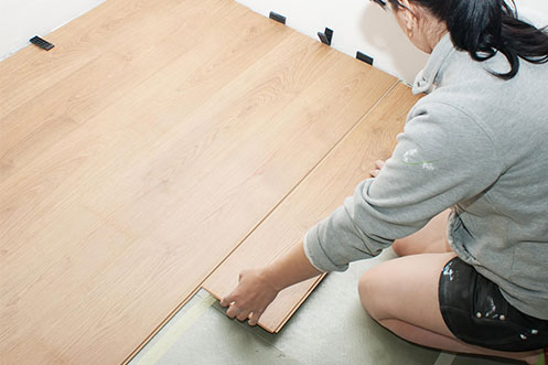 Lady installing laminate floor | Nampa Floors